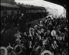 British Men Leaning Out of Railway Carriages and Saying Goodbye to People on a Crowded..., 1939. Creator: British Pathe Ltd.