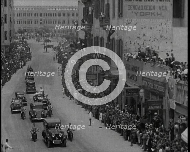 Crowds Watching a Convoy Driving Through the Streets, 1936. Creator: British Pathe Ltd.