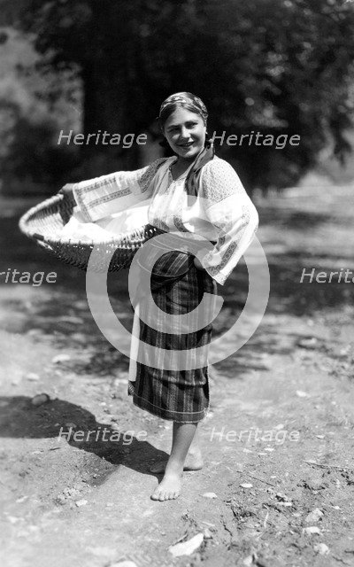 Woman carrying a large basket, Bistrita Valley, Moldavia, north-east Romania, c1920-c1945. Artist: Adolph Chevalier