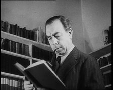 J.B. Priestly Reading and Smoking a Pipe, 1930s. Creator: British Pathe Ltd.