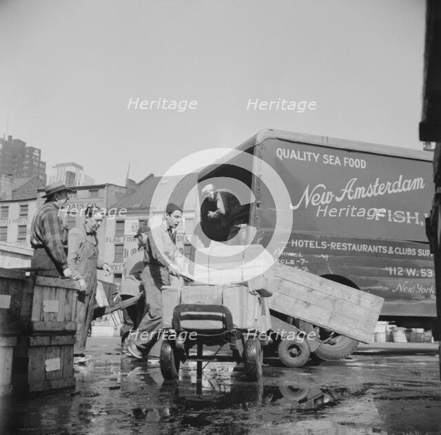 Loading boxes of fish to be shipped to hotels and restaurants at the Fulton fish..., New York, 1943. Creator: Gordon Parks.