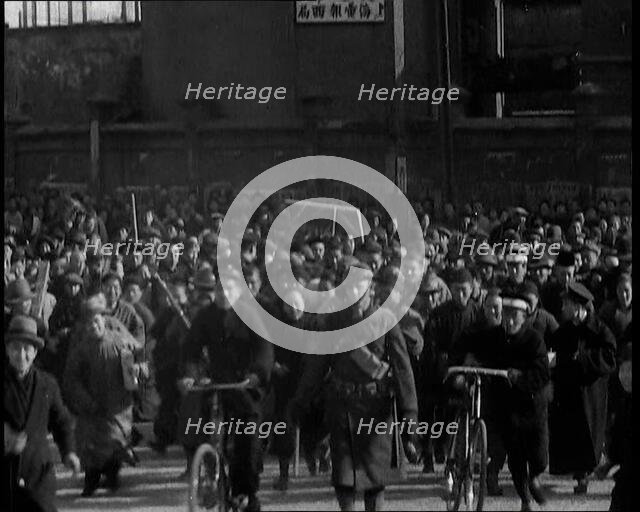 Chinese Refugees Including Several With Bicycles Spilling Through Barriers..., 1937. Creator: British Pathe Ltd.