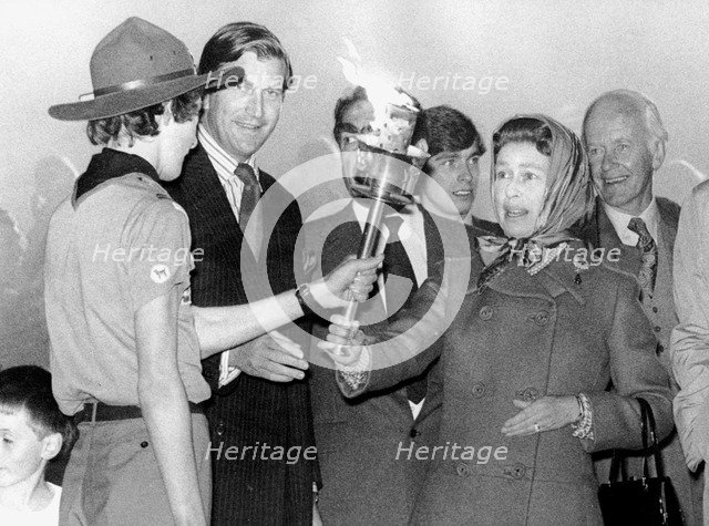 Queen Elizabeth II is handed a torch to light a bonfire with, Snow Hill, Windsor Great Park, 1977. Artist: Unknown
