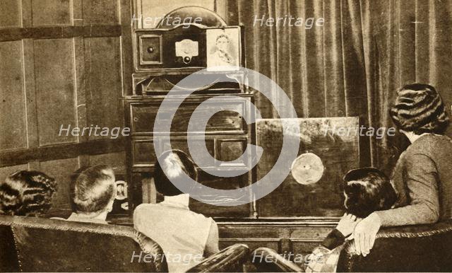 People watching an early television broadcast, c1930, (1933). Creator: Unknown.