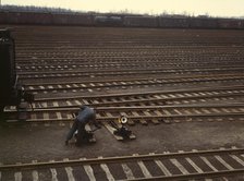 Switchman throwing a switch at C & NW RR's Proviso yard, Chicago, Ill., 1943. Creator: Jack Delano.