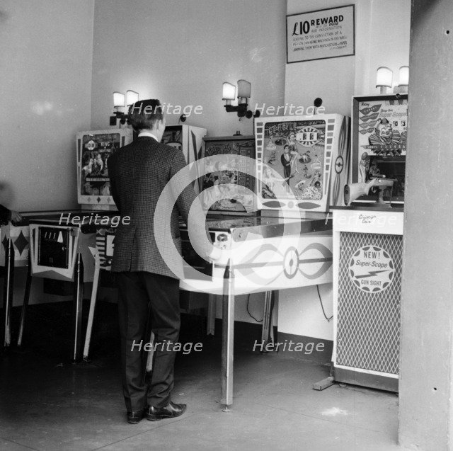 Man playing pinball in a London amusement arcade, c1966-67. Artist: Henry Grant