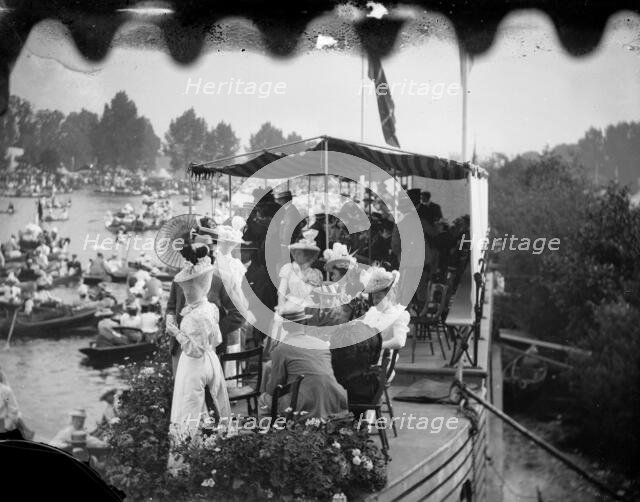 Men and women take tea on a college barge overlooking the Henley Royal Regatta, Oxfordshire, 1897. Creator: Henry Taunt.