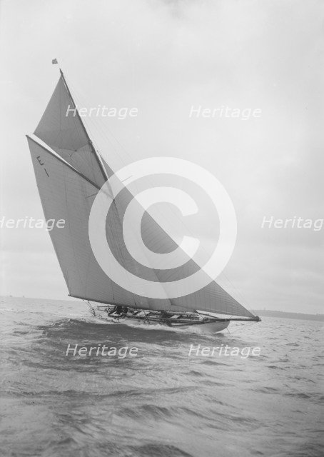 The 12 Metre yacht 'Alachie' makes swift progress upwind, 1911. Creator: Kirk & Sons of Cowes.