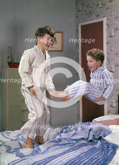 Two boys jumping on a bed, c1955.  Creator: Arthur Charles Kirby Ware.