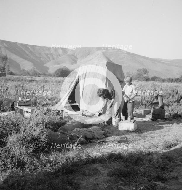 Possibly: Fatherless migratory family camped behind gas station, Yakima Valley, Washington, 1939. Creator: Dorothea Lange.