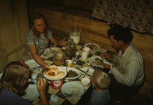 The Faro Caudill family eating dinner in their dugout, Pie Town, New Mexico, 1940. Creator: Russell Lee.