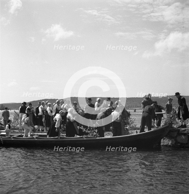 People arrive in long boats, called church boats, Midsummer's Eve and Day celebrations, 1941. Artist: Torkel Lindeberg