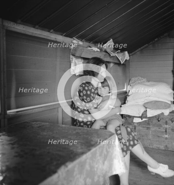 Mother with sick baby awaits arrival of FSA camp resident nurse, Tulare County, CA, 1939. Creator: Dorothea Lange.
