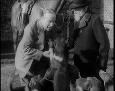 Prime Minister Stanley Baldwin Petting Dogs. Beside Him a Male Civilian Stands Next to a Horse, 1924 Creator: British Pathe Ltd.