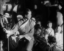 A Female Civilian in a Traditional Robe Dancing With Sabres As People Watch Her Performanc..., 1932. Creator: British Pathe Ltd.