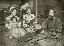 'Ainu Man and Women at Home', 1910. Creator: Herbert Ponting.