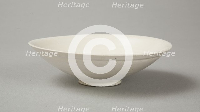 A shallow cream glazed bowl with rolled rim andraised footrim, Tang dynasty, c.800-900. Artist: Unknown.