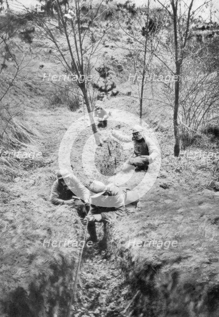 Fench sappers in gas masks re-laying telephone lines after a bombardment, 1918. Artist: Unknown
