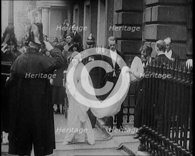 The Duke of York and Lady Elizabeth Bowes-Lyon Emerging from a House on Their Wedding Day, 1920. Creator: British Pathe Ltd.