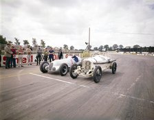 A 1914 and 1937 Grand Prix Mercedes racing cars at the starting line. Artist: Unknown