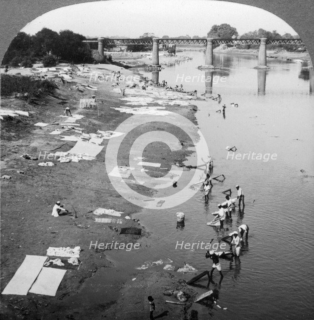 Dbobies washing clothes in the Goomti River, near Lucknow, India, 1900s.Artist: Underwood & Underwood