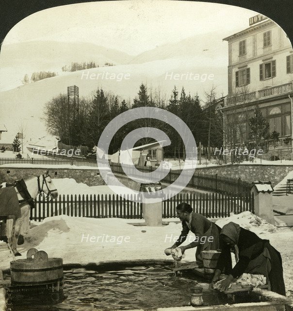 Women washing clothes at the public fountain in midwinter, Zuoz, Switzerland. Artist: HC White