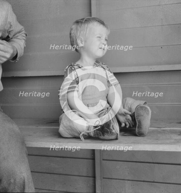 Baby with club feet wearing homemade splints, FSA camp, Tulare County, California, 1939. Creator: Dorothea Lange.