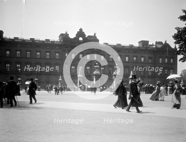 Sightseers crowd around the gates of Buckingham Palace, London. Artist: Unknown
