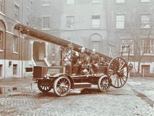 Firemen aboard a motor fire escape vehicle, London Fire Brigade Headquarters, London, 1909. Artist: Unknown.