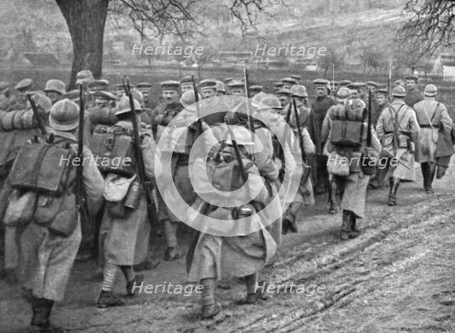 'Dans la Bataille; Une releve d'infanterie qui monte en ligne se croise avec un convoi..., 1918. Creator: Unknown.