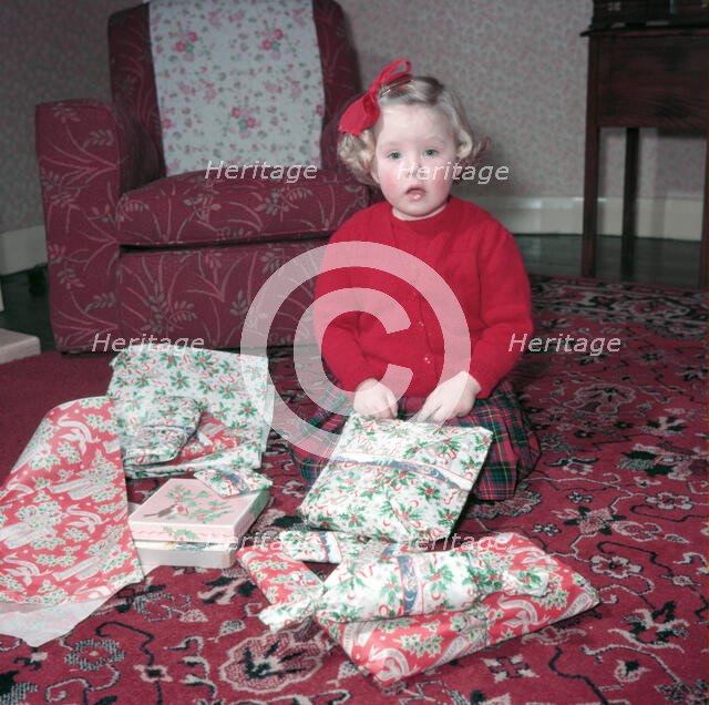 Girl opening her Christmas presents, c1955.  Creator: Arthur Charles Kirby Ware.