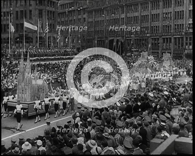 Participants Walking Alongside Floats in a Large Parade During the World Congress for..., 1938. Creator: British Pathe Ltd.