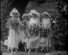 British Bridesmaids Walking Through a Flowery Arch, Holding Flowers, 1921. Creator: British Pathe Ltd.