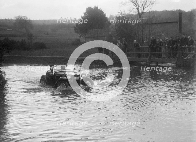 MG PA driving through a ford during a motoring trial, 1936. Artist: Bill Brunell.