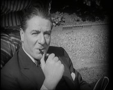 Matheson Lang Relaxing in a Deck Chair Smoking a Pipe, 1920s. Creator: British Pathe Ltd.