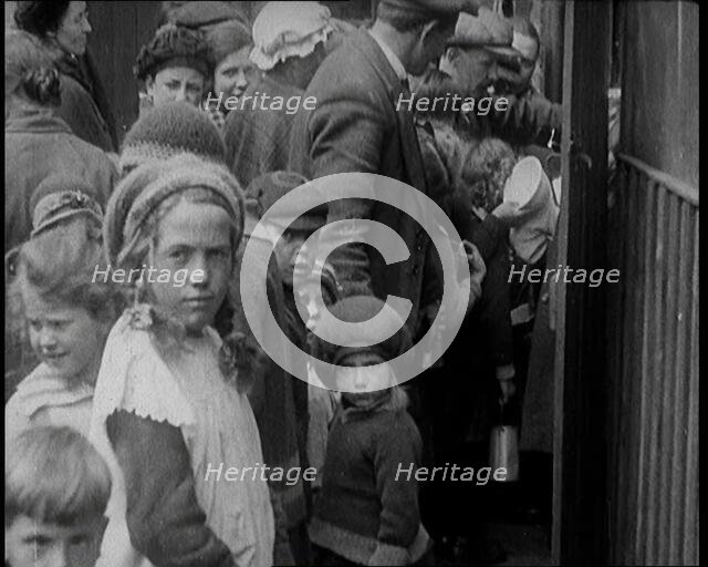 Group of Children Walking Out of a Food Kitchen With Bread And Soup, 1924. Creator: British Pathe Ltd.
