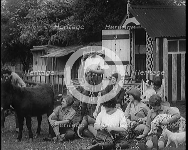 A Group of Young Female Civilians Sitting Outdoors with Various Animals Around Them, 1920. Creator: British Pathe Ltd.
