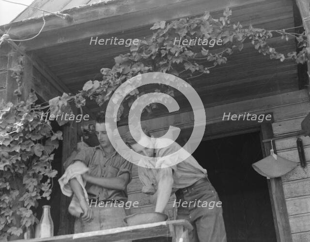 Hop farmer's sons, washing for noon meal on back porch, Independence, Polk County, Oregon, 1939. Creator: Dorothea Lange.