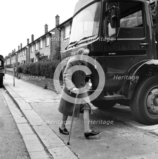 Old woman and truck on a London street, 1977. Artist: Henry Grant