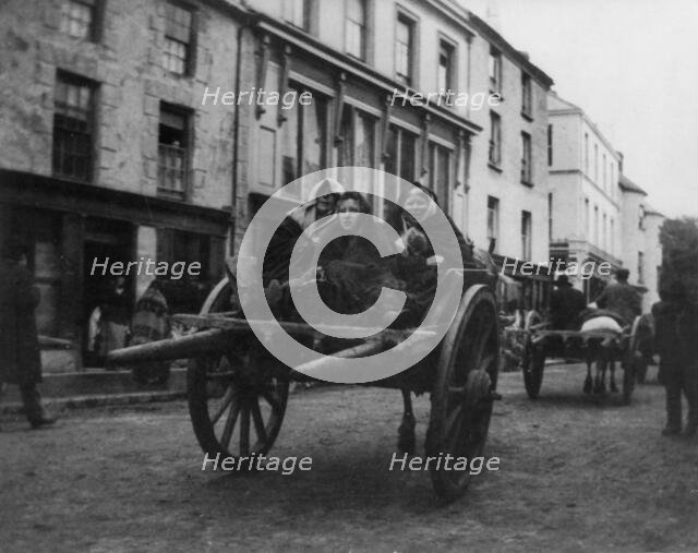 Killarney - 3 Irish women going to a funeral in a horse-drawn cart, (1899?). Creator: Frances Benjamin Johnston.