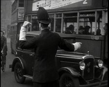 A Police Officer Guiding Traffic on the Streets of London, 1936. Creator: British Pathe Ltd.