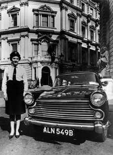 Female chauffeur standing by a 1964 Morris Oxford, 1964. Artist: Unknown