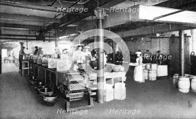 Where machinery is paramount: filling and weighing packages of lard, 1909. Creator: Unknown.