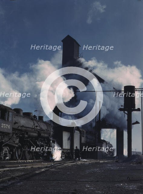 Locomotives over the ash pit at the roundhouse and coaling station...Chicago, Ill., 1942. Creator: Jack Delano.