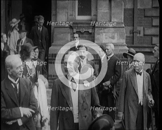 King George V Accompanied by a Group of Officials Emerging from a Building , 1924. Creator: British Pathe Ltd.