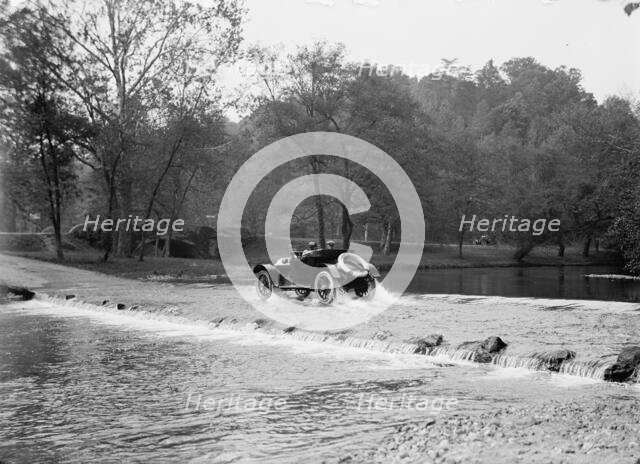 Couple In Automobile Fording A River At A Low Water Crossing Near A Small Stone Bridge, ca.1913-1918 Creator: Harris & Ewing.