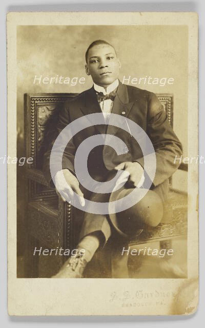 Photographic postcard of a seated man holding a bowler hat, 1904-1918. Creator: Unknown.