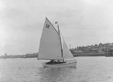 A Hamble River Class dinghy (No 12) sailing close-hauled, 1921. Creator: Kirk & Sons of Cowes.