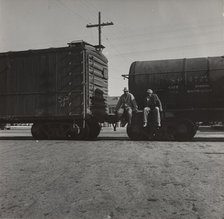 Colored itinerants on oil tank cars passing through Kingsbury, California, 1938. Creators: Farm Security Administration, Dorothea Lange.