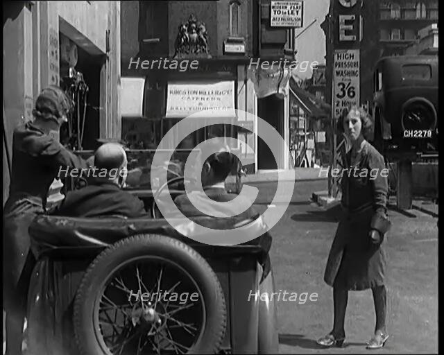 Female Civilians Working Petrol Pumps in a Garage and Filling up a Car, 1931. Creator: British Pathe Ltd.